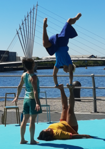 3 acrobats perform an acrobalance trick.
